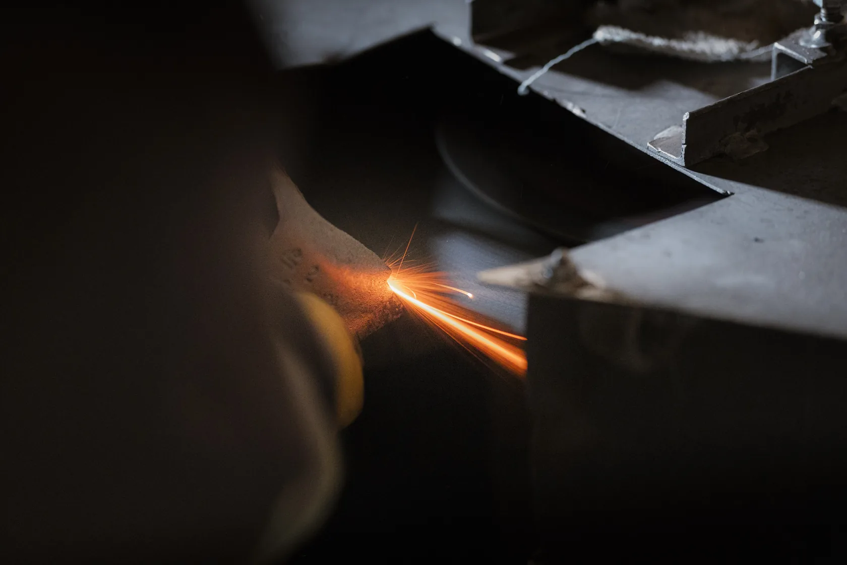Sparks fly as a worker grinds a part at the bench in the GEN shop in Coaldale, Alberta