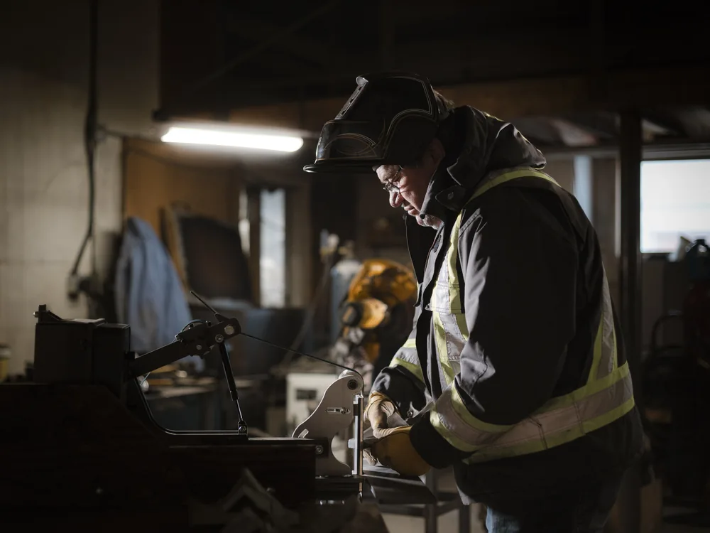 A welder grinding a part at the bench in the GEN shop